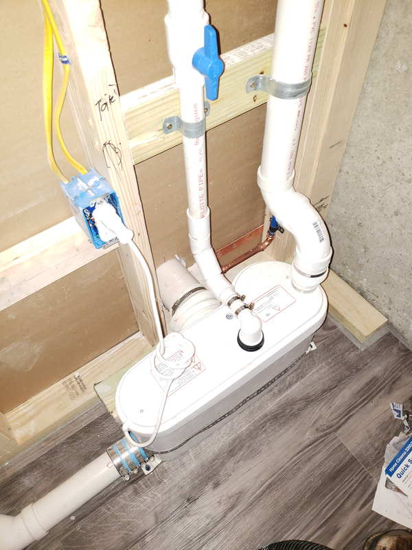 new basement Sani-flow installation before toilet and vanity installation